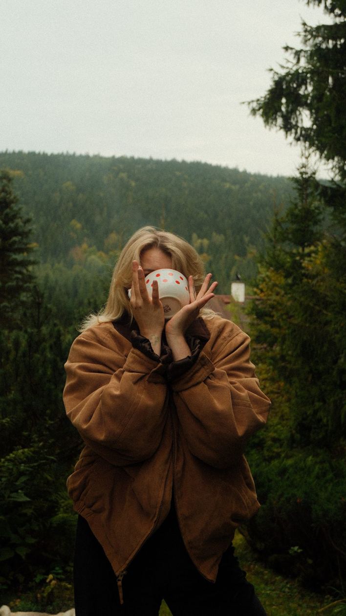 Portrait with a coffee cup in a pine forest
