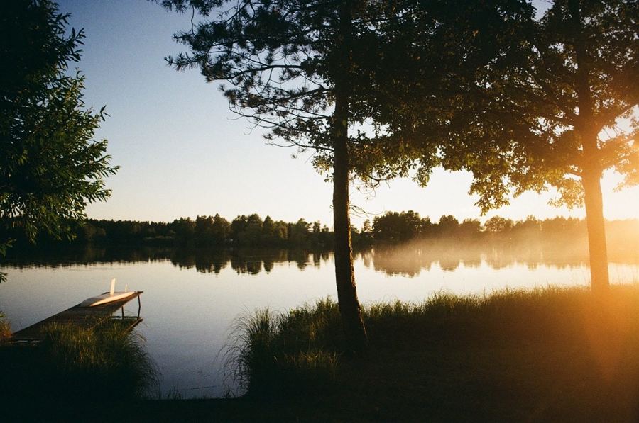 Sunrise over a still lake with a small dock